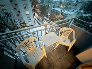 two chairs and a table on a balcony at Apartament w centrum Konina in Konin