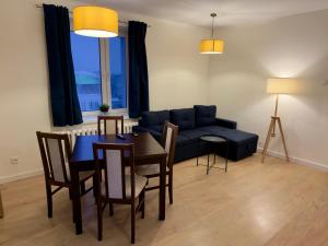 a living room with a couch and a table and chairs at Apartament w centrum Konina in Konin
