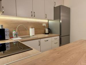 a kitchen with white cabinets and a stainless steel refrigerator at Apartament w centrum Konina in Konin +7 photos