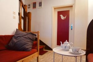 ein Wohnzimmer mit einer Couch und einem Tisch mit einer Teekanne in der Unterkunft La Suzanne in Brantôme
