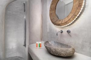 a bathroom with a stone sink and a mirror at Boutique Villa Aquata Private pool in Mikonos +48 photos