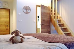 a stuffed animal sitting on a bed in a bedroom at Gostišče Jezersko in Zgornje Jezersko