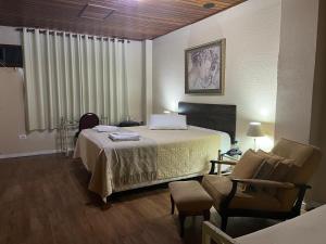 a hotel room with a bed and a chair at Skalla Hotel Nova Odessa in Nova Odessa +128 photos