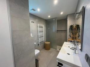a bathroom with a sink and a toilet and a mirror at NEW Apartment, Sea Front & Shared Pool in Quarteira +11 photos