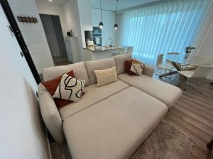 a living room with a couch with pillows on it at NEW Apartment, Sea Front & Shared Pool in Quarteira