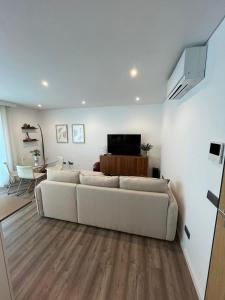 a living room with a white couch and a table at NEW Apartment, Sea Front & Shared Pool in Quarteira