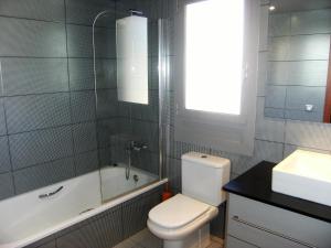 a bathroom with a toilet and a tub and a sink at Apartment in Estartit with garden in L'Estartit