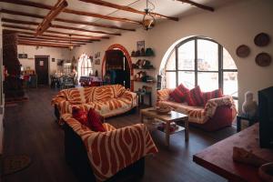 a living room with two couches and an arched window at CaminAndes Hostal in San Pedro de Atacama