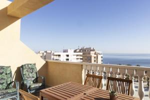 a balcony with a table and chairs and the ocean at Penthouse Pink seafront in La Mata