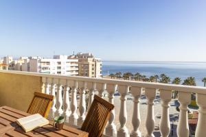 a balcony with a table and chairs and the ocean at Penthouse Pink seafront in La Mata