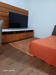 a bedroom with a bed and a flat screen tv at Mar e descanso in São Sebastião