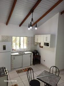 a kitchen with white cabinets and a table and chairs at Mar e descanso in São Sebastião