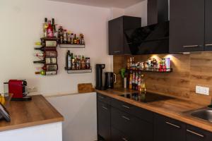 a kitchen with a counter with bottles on the wall at Gemütliches Gästezimmer mit gemeinsamer Küche, Wohnzimmer & Balkon in Nassereith