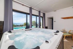 a jacuzzi tub with a view of a pool at Villa The Sunset View in Nehaj