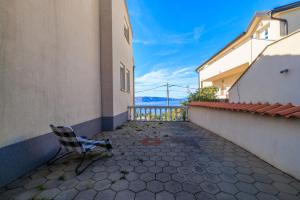 a chair sitting in a courtyard between two buildings at Villa The Sunset View in Nehaj
