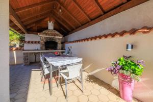 a table and chairs on a patio with a pizza oven at Villa The Sunset View in Nehaj +63 photos
