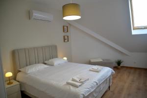 a bedroom with a white bed with towels on it at PANTEX Centar Zlatibor in Zlatibor