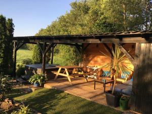 a wooden pergola with a picnic table in a garden at Holiday Home in Reutum with Bubble Bath in Beekdorp