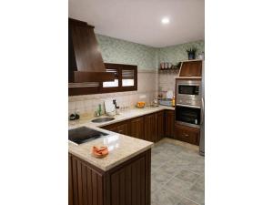 a kitchen with wooden cabinets and a counter top at Chalet in Rivero de Posadas with Pool in Rivero de Posadas
