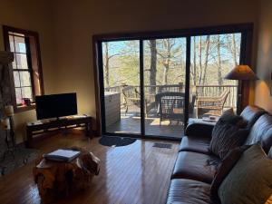 a living room with a couch and a large sliding glass door at Red Top Tree House in Highlands