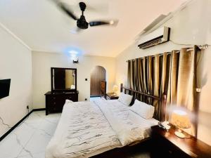 a bedroom with a large bed and a television at Waves Guest House Clifton Khi in Karachi