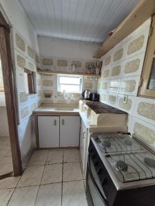 a small kitchen with a stove and a sink at Casa Hermena in Santa Vitória do Palmar