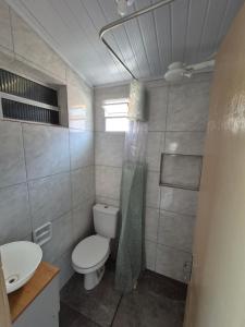 a small bathroom with a toilet and a sink at Casa Hermena in Santa Vitória do Palmar