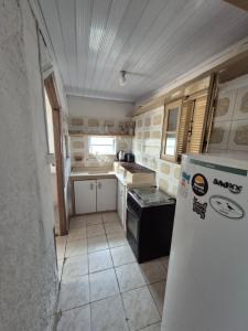 a small kitchen with a stove and a refrigerator at Casa Hermena in Santa Vitória do Palmar +7 photos