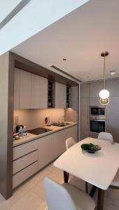 a kitchen with a white table and white chairs at ADDRESS RESIDENCES BEACH RESORT BAHRAiN in Rayyā +21 photos