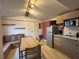 a kitchen and living room with a table and a couch at Chaleureux Tiny Home à 45 mn du Zoo de Beauval in Veuzain-sur-Loire