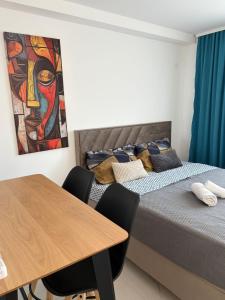 two beds in a room with a table and a painting at Nik 2 in Kruševac