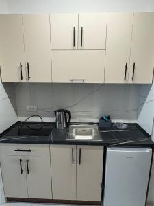 a small kitchen with a sink and white cabinets at Nik 2 in Kruševac