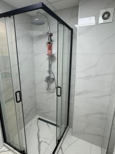 a shower with a glass door in a bathroom at Nik 2 in Kruševac