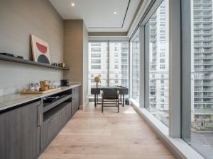 a kitchen with large windows and a dining room with a table at Stay One Chicago in Chicago