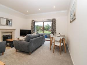 a living room with a couch and a table at Cairndhu in Boʼness