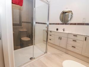 a bathroom with a shower with a toilet and a sink at Cairndhu in Boʼness +25 photos