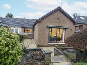 a brick house with large windows and a garden at Cairndhu in Boʼness