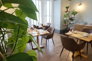 a restaurant with wooden tables and chairs and a plant at The Devonshire Villa in Ilfracombe