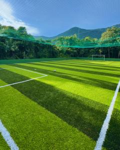 a green soccer field with a net on it at Hotel Pousada Tambayba in Maresias