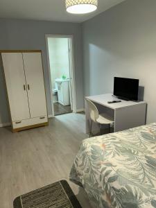 a bedroom with a bed and a desk with a computer at Ivydale Guest House in Syston