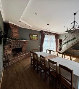 a dining room with a table and chairs and a fireplace at Complex MAYARIV in Makariv