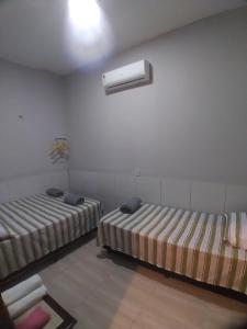 a room with two beds and a white wall at Yanne chalé 1 in Barra Grande