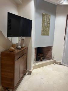 a living room with a flat screen tv and a fireplace at Villa Al Firdaous in Tiznit