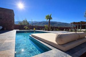 a swimming pool with an inflatable bed in front of a house at Villa Al Firdaous in Tiznit