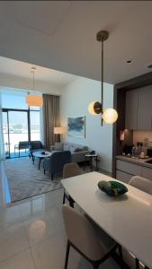 a kitchen and living room with a table and chairs at ADDRESS RESIDENCES BEACH RESORT BAHRAiN in Rayyā