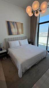 a bedroom with a large white bed and a large window at ADDRESS RESIDENCES BEACH RESORT BAHRAiN in Rayyā