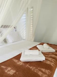 ein Bett mit zwei Handtüchern darauf in der Unterkunft Kazaperrok in Grand-Bourg