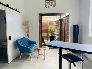 ein Esszimmer mit einem blauen Stuhl und einem Tisch in der Unterkunft Kazaperrok in Grand-Bourg