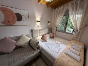 a living room with a couch and a window at villa Heljos apartaments in Vlorë