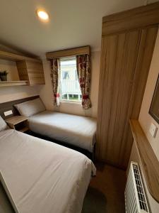 a small room with two beds and a window at Chesil View in Wyke Regis